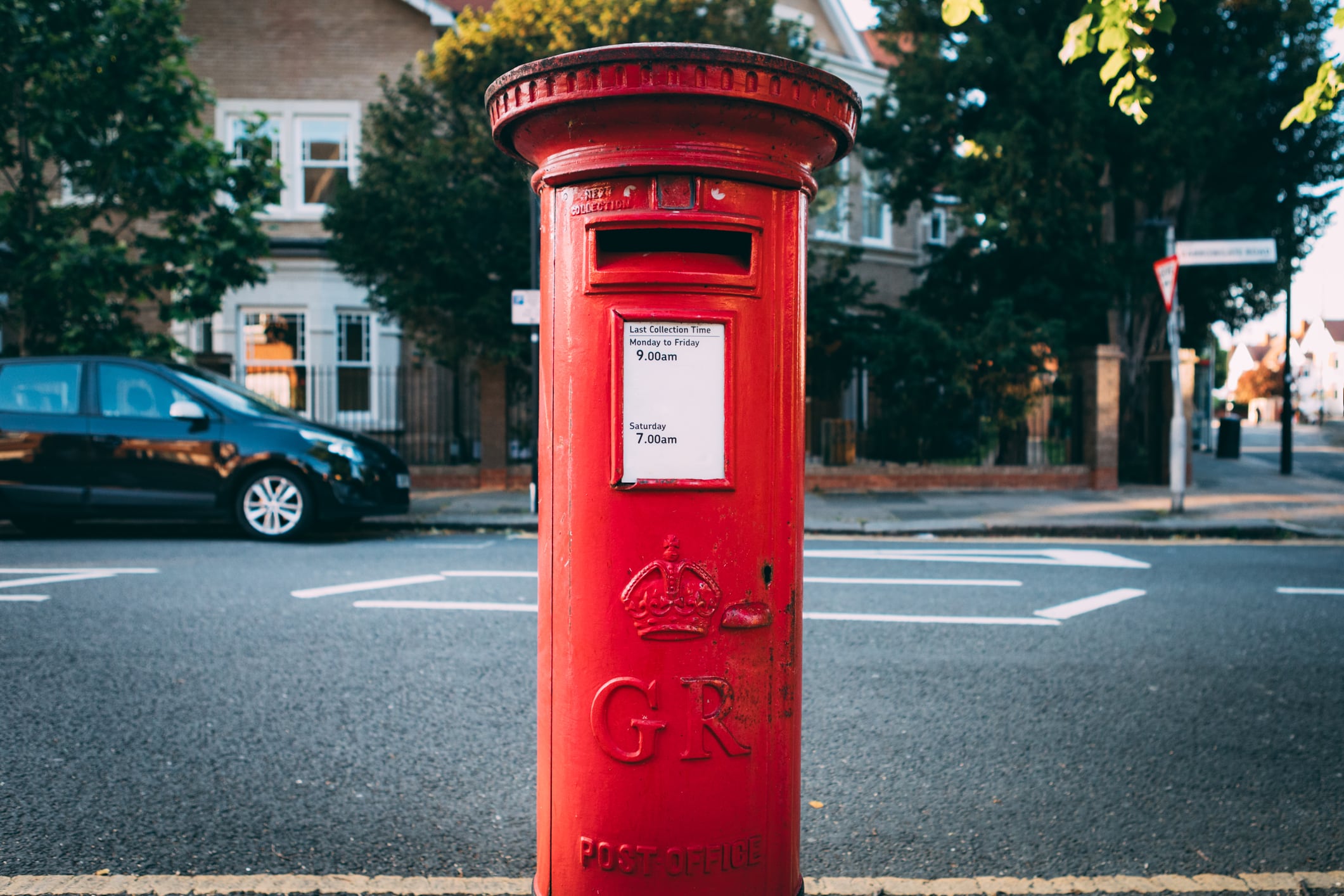 Red British postal box on the street.Un buzón con las siglas de Jorge VI en Reino Unido.