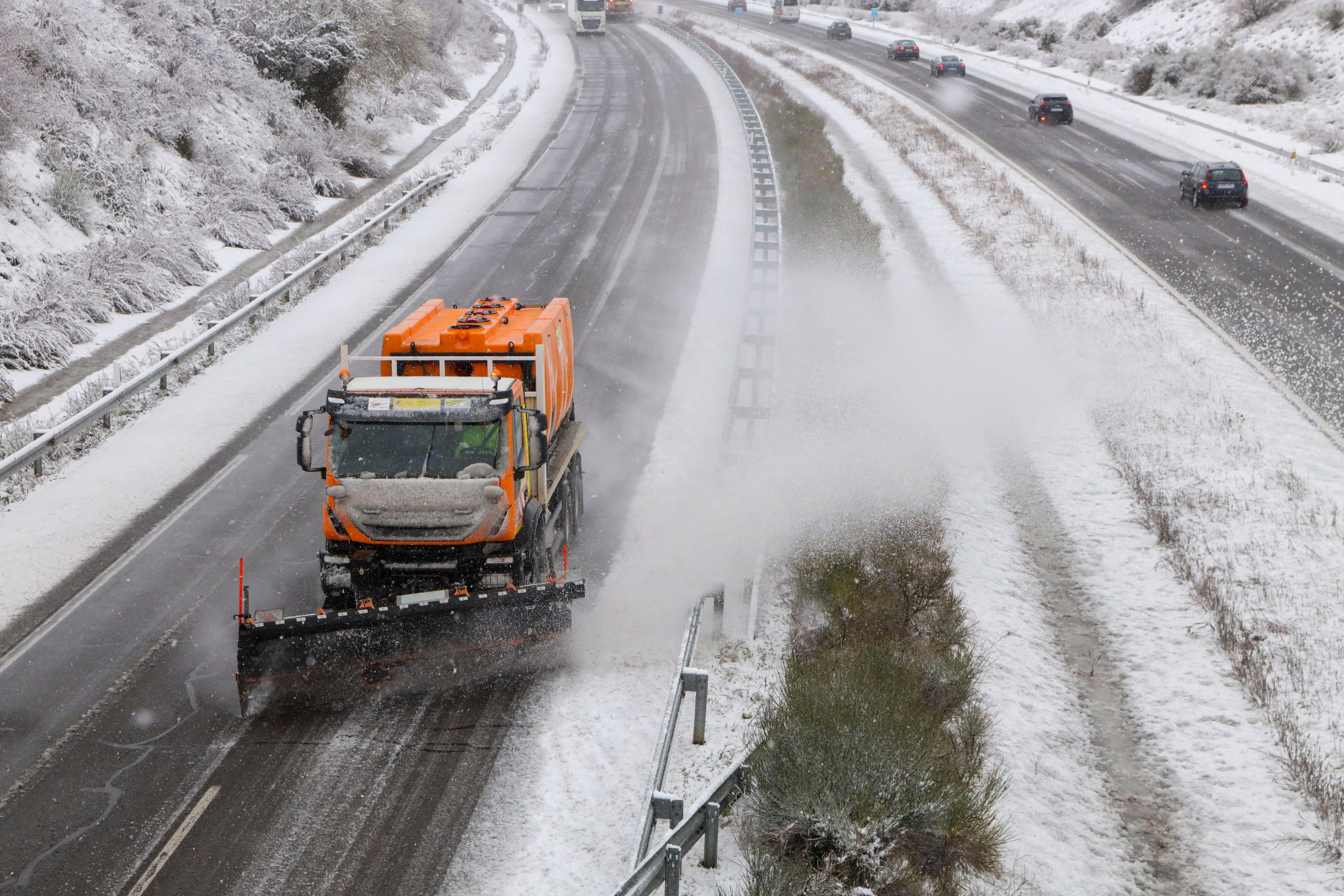 Una máquina quitanieves limpia la nieve de una autovía.