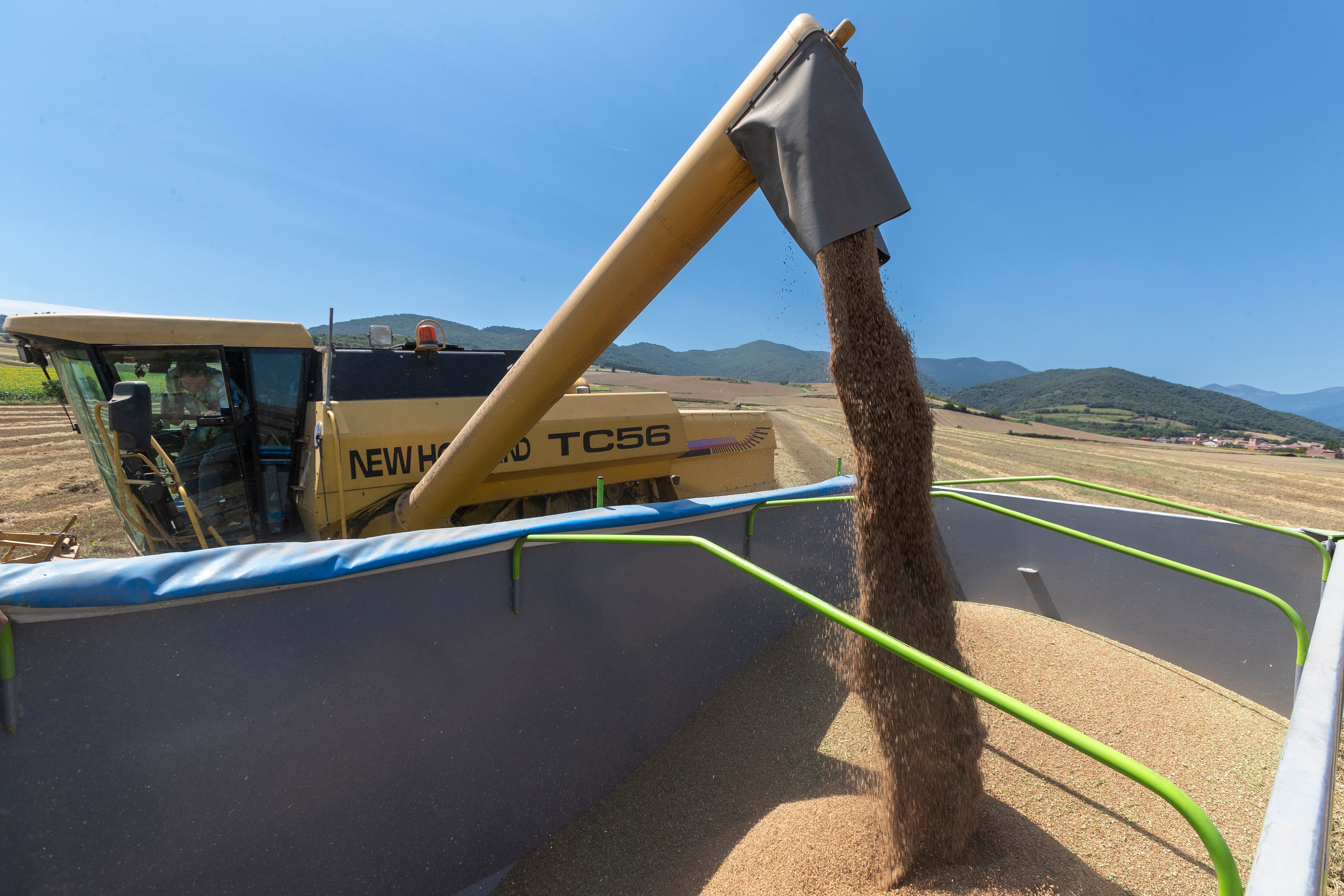 ZARAGOZA 09.07.2023.- Cuando la cosecha de cereal se acerca a su fin se espera que esta sea escasa, con la sequía como resposable de su baja producción. En la imagen una cosechadora deposita en un remolque el grano cosechado.-EFE/JAVIER BELVER
