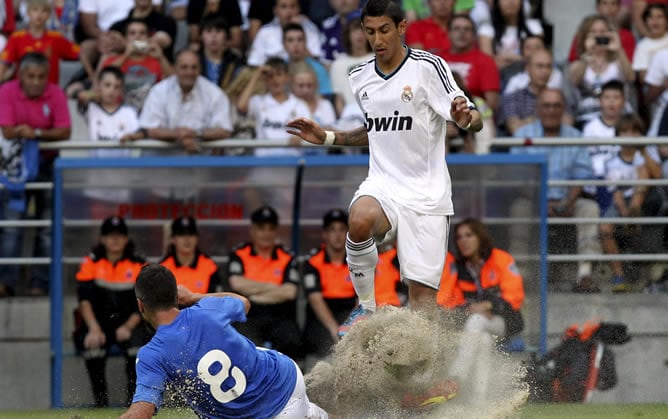 El mediapunta argentino del Real Madrid, Ángel Di María (d), lucha el balón con Diego Cervero, del Real Oviedo