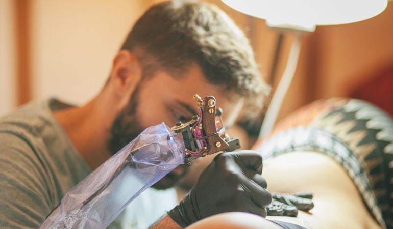 Un hombre haciendo un tatuaje.