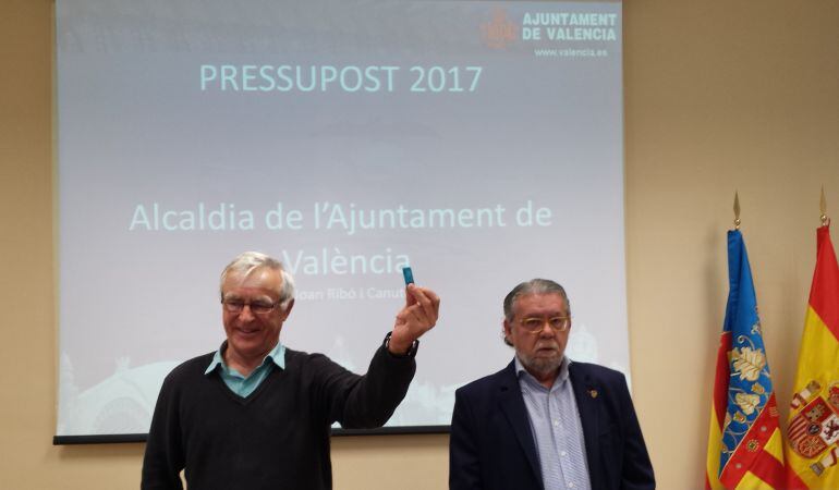 El alcalde de Valencia Joan Ribó muestra el pen que contienen las cuentas municipales de 2017 aprobadas este miércoles por la junta de gobierno. A su izquierda, el concejal de hacienda Ramón Vilar