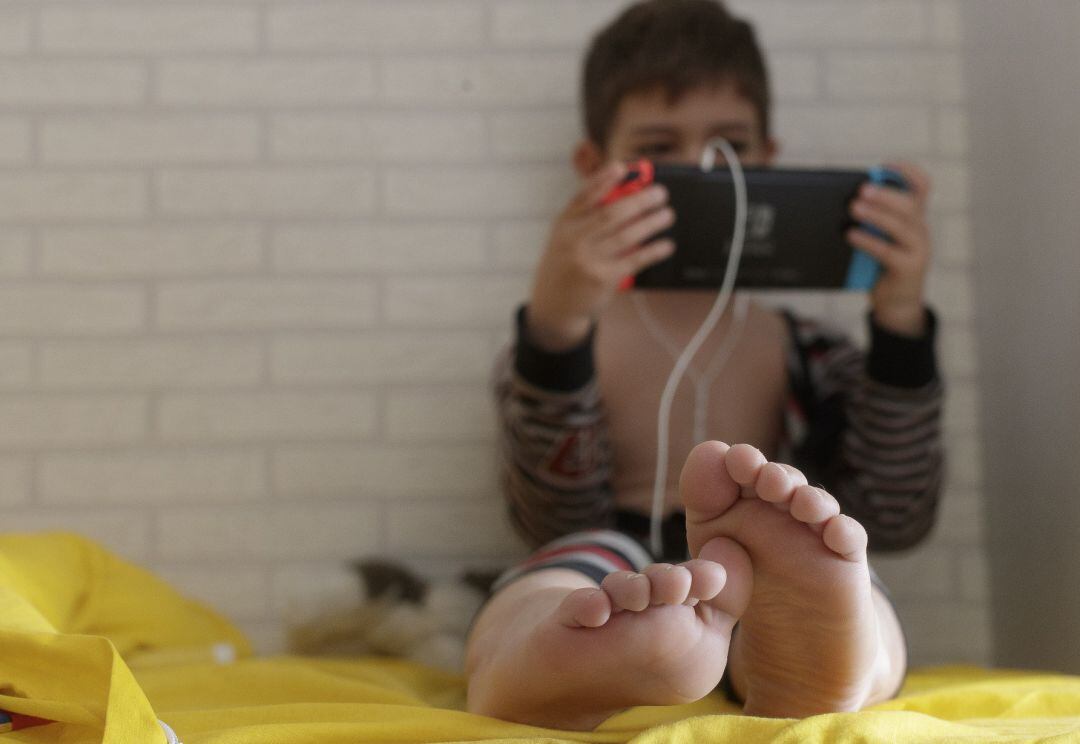 Un niño de 8 años juega y habla con sus amigos a través de una videoconsola.