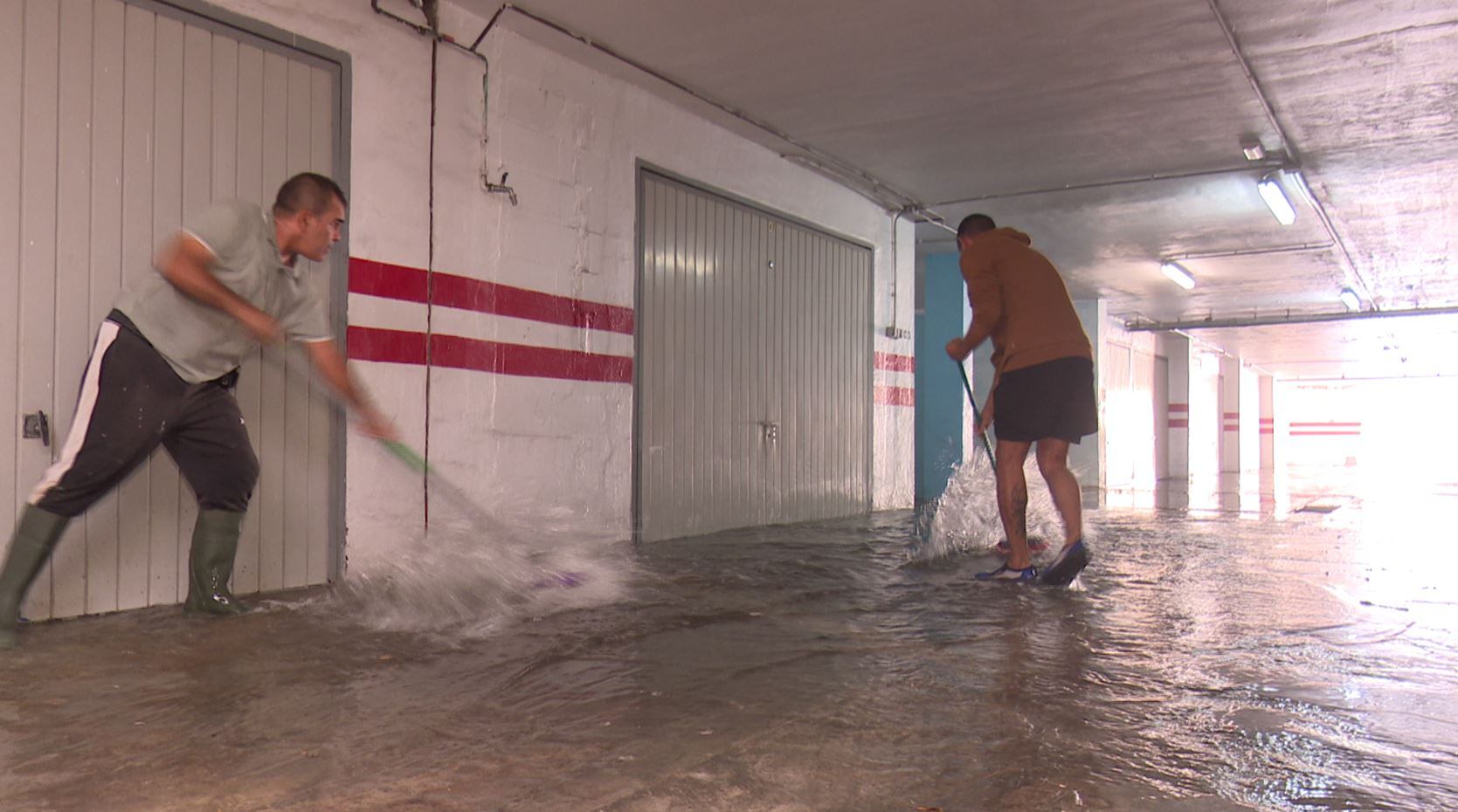 Vecinos tratan de sacar el agua de un garaje inundado en la playa de Gandia el pasado 29 de septiembre