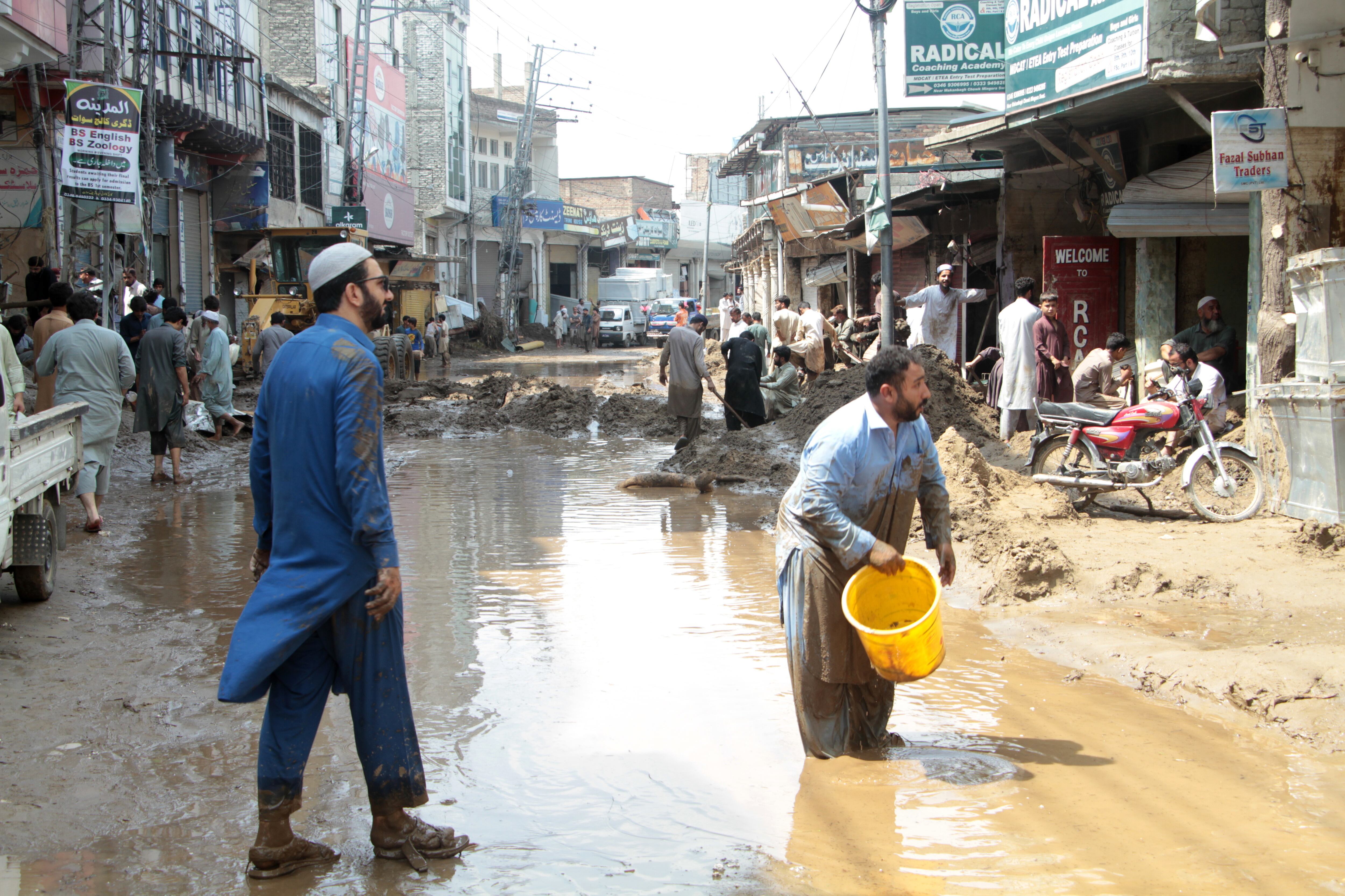 La población trata de despejar las zonas donde las lluvias monzónicas han arrasado con edificios y comercios.