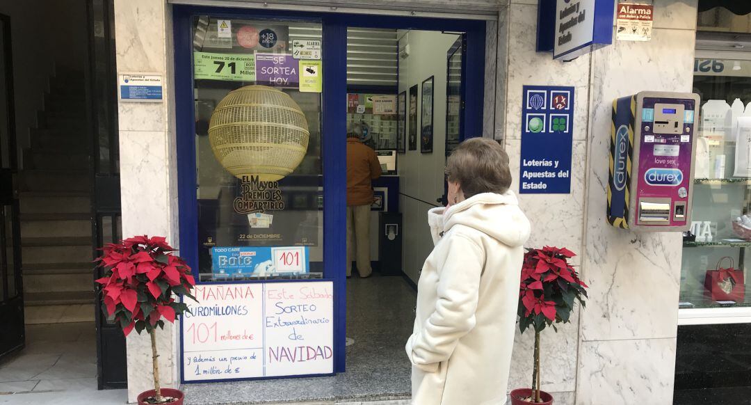 Una señora espera en la puerta de una Administración de Loterías de la capital.