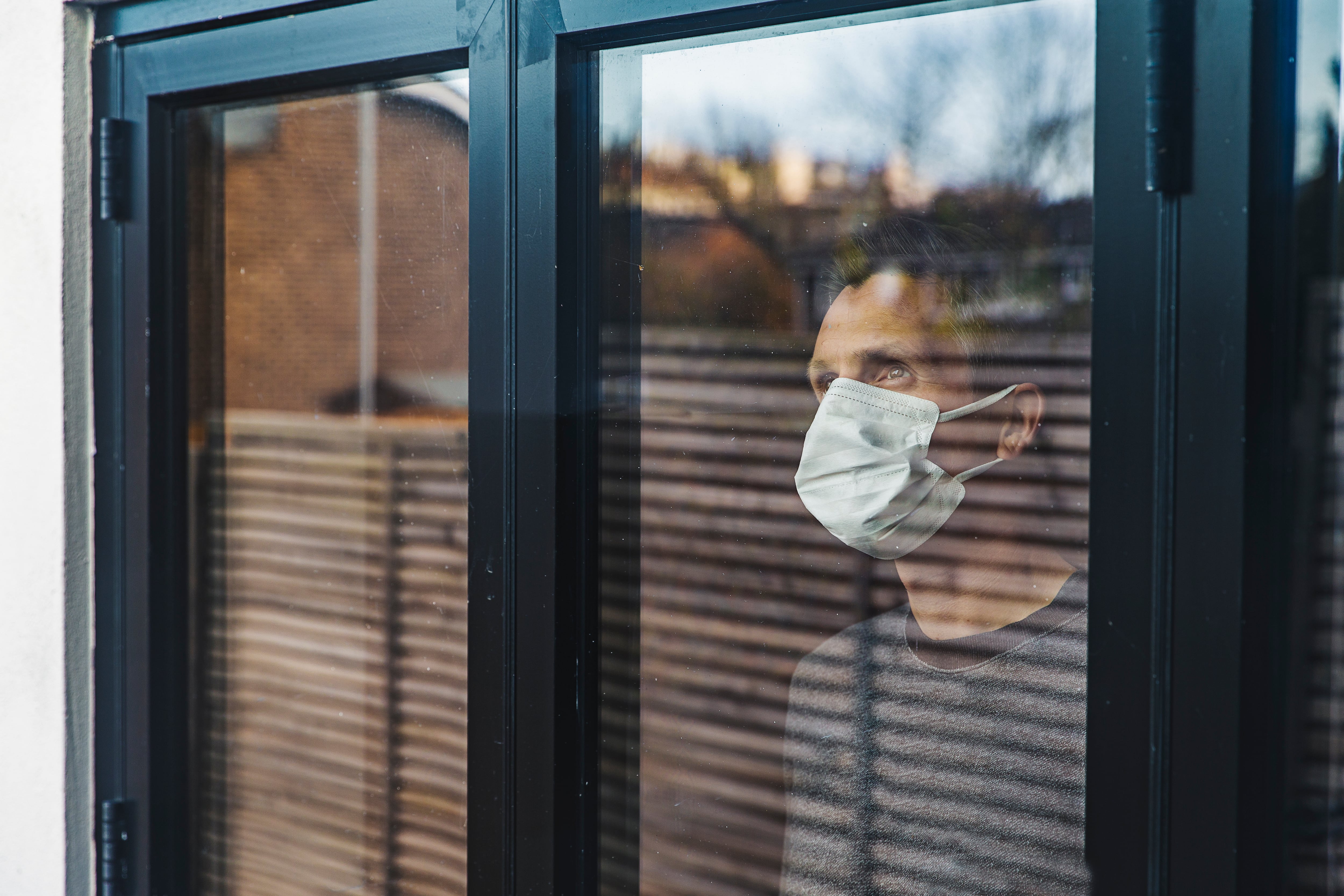 Un hombre mira por la ventana durante el estado de alarma (Getty Images)