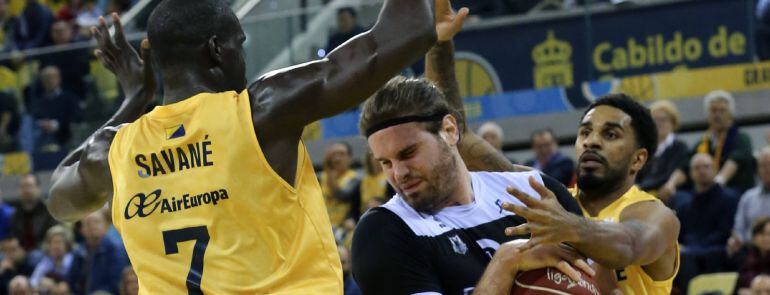 GRA278. LAS PALMAS DE GRAN CANARIA. 14022016. Los jugadores del Herbalife Gran Canaria Sitapha Savané (i) y dennis Seeley (d) y el pívot griego del Dominion Bilbao Basket Georgios Bogris (c) durante el partido de la vigésima jornada de la liga ACB que amb