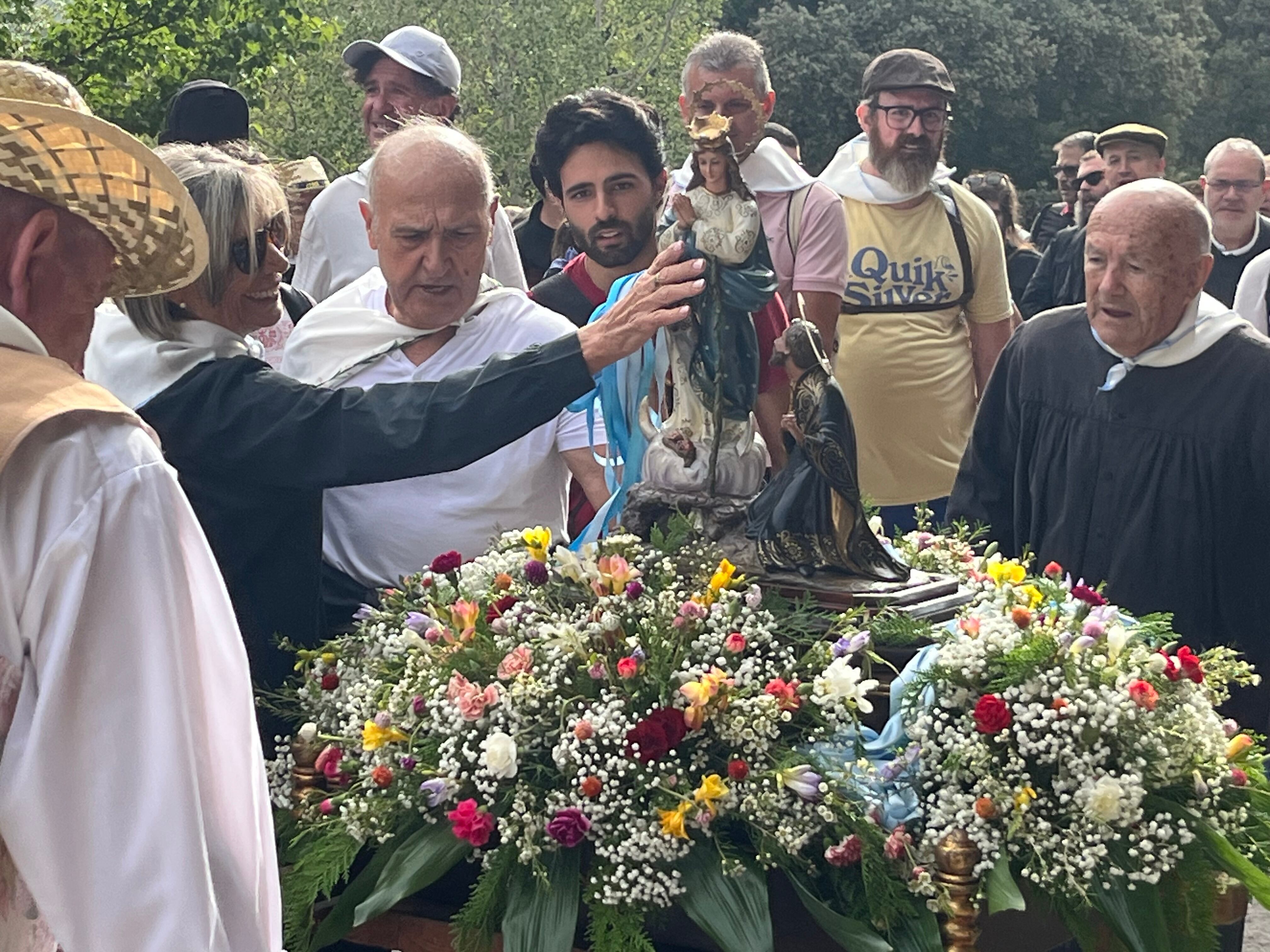 Una devota acariciando la imagen de la Virgen de los Lirios antes de la llegada al Santuario.