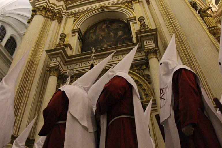 Nazarenos de la Hermandad de los Estudiantes durante su estación de penitencia en el interior de la Catedral