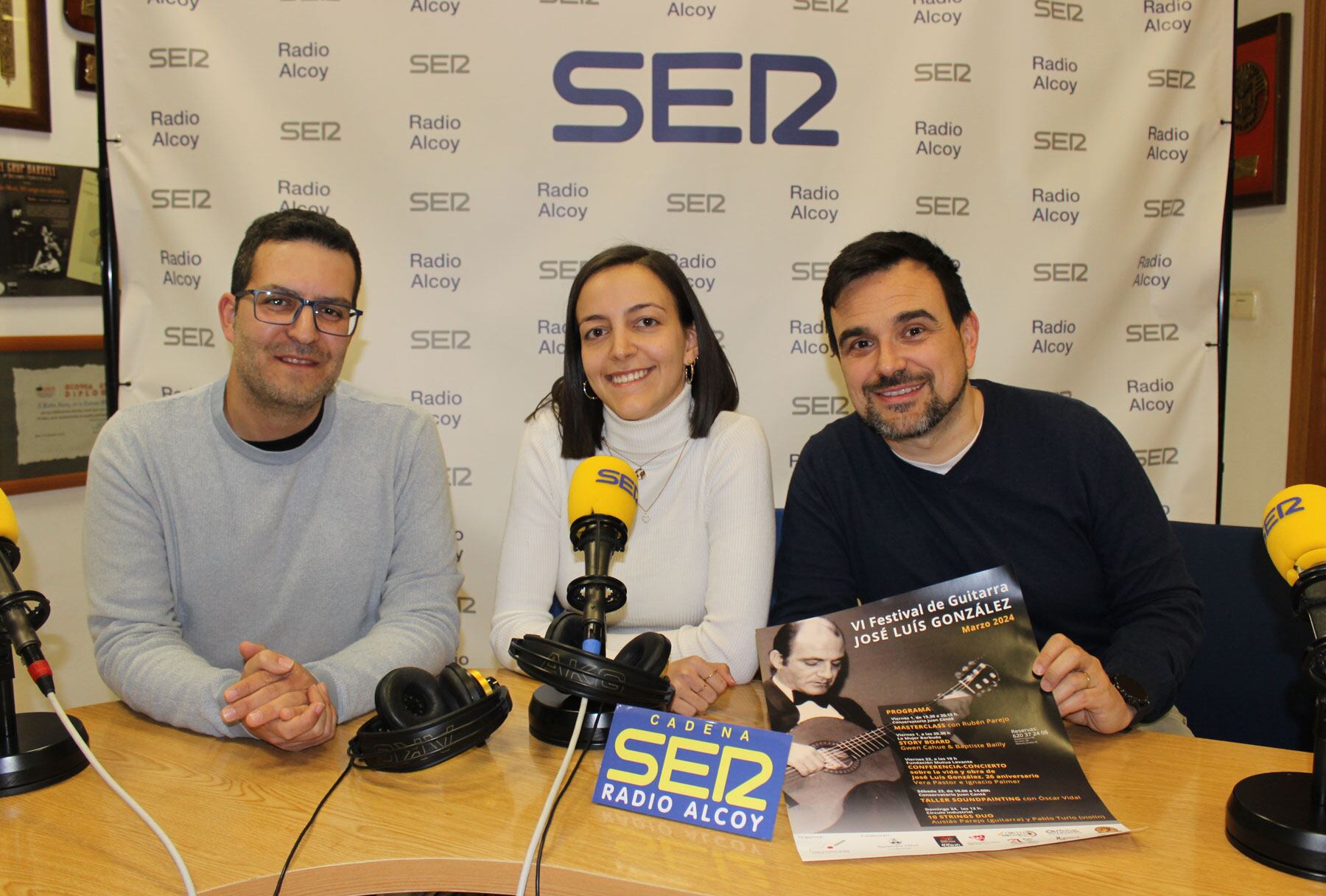 Joan Aracil, Vera Pastor i Nacho Palmer, en l&#039;estudi central de Radio Alcoy amb un cartell dels actes preparats per la sexta edició del festival José Luis González