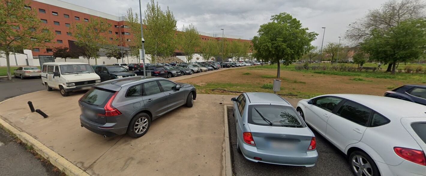 Imagen de vehículos estacionados en la acera junto al hospital general de Ciudad Real