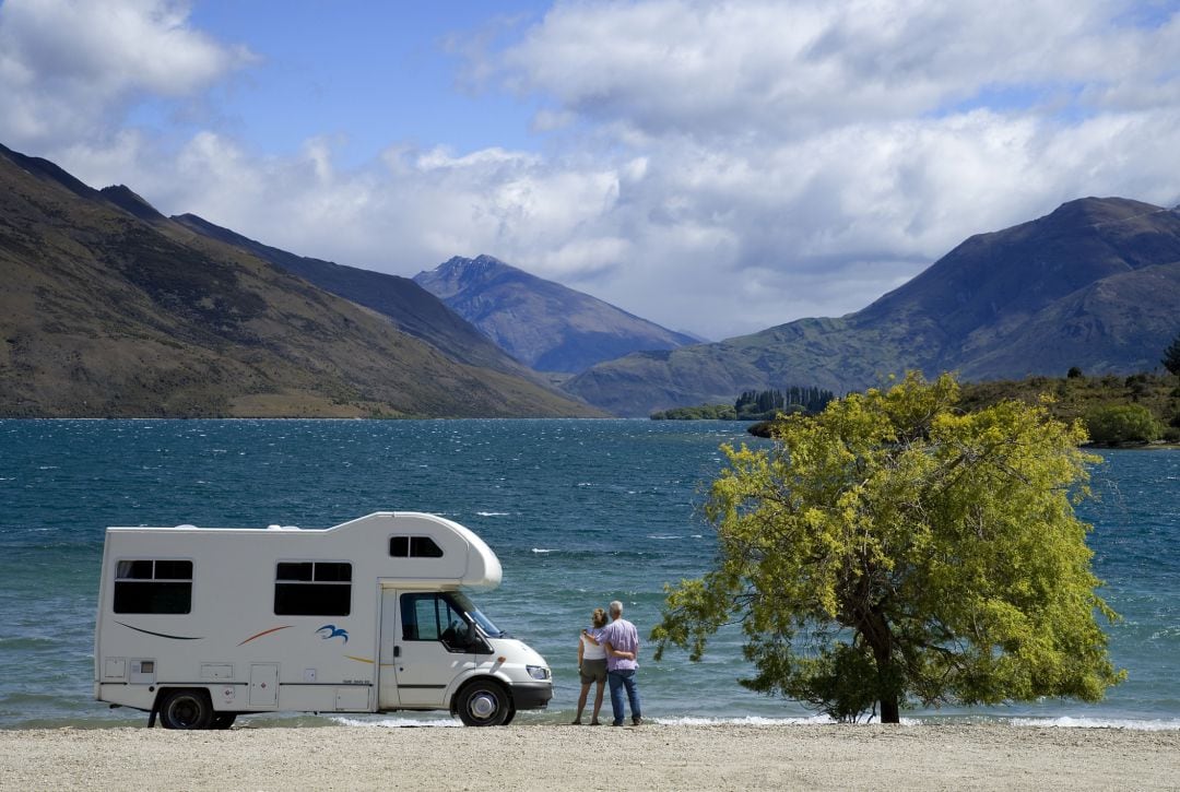 Una pareja contempla el paisaje junto a su autocaravana