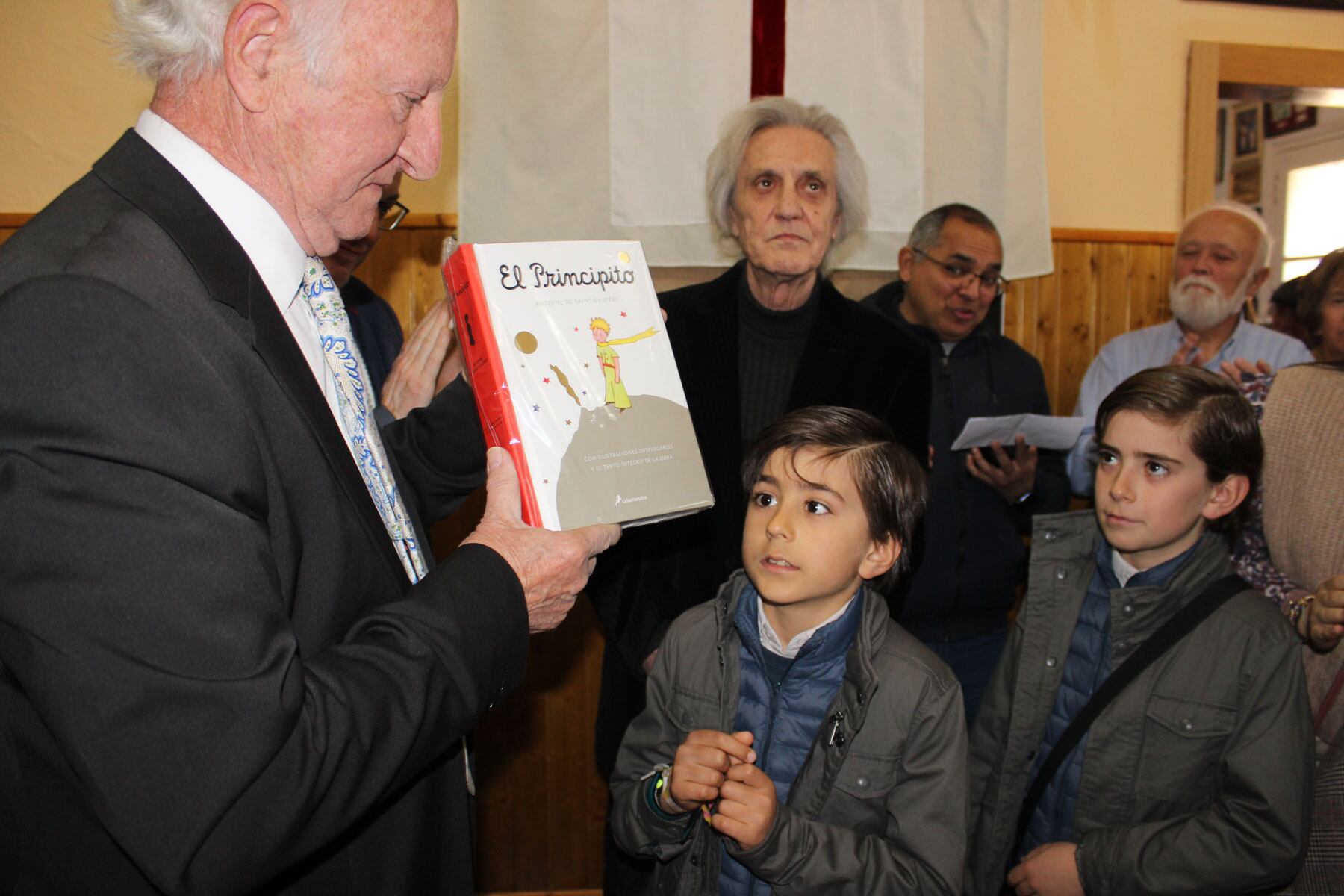 El Sant Jordiet, Mauro Abellán, y su hermano, Alonso, en el momento de la entrega del regalo del libro 'El principito' de manos del presidente de la penya, Armando Soler