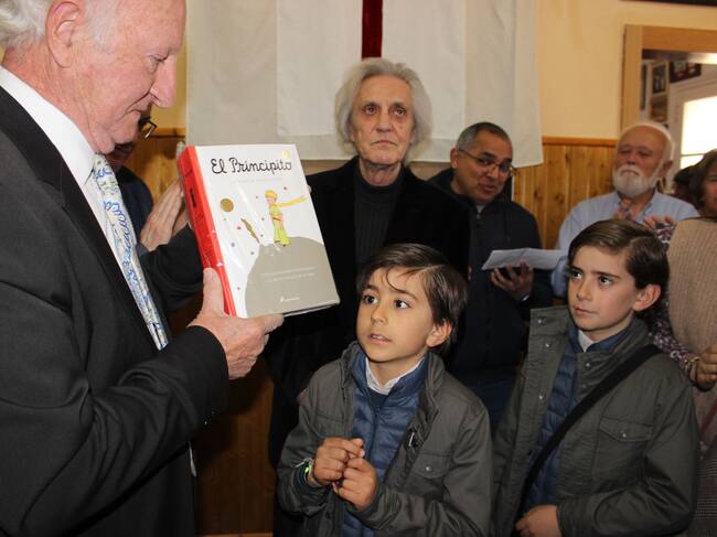 El Sant Jordiet, Mauro Abellán, y su hermano, Alonso, en el momento de la entrega del regalo del libro 'El principito' de manos del presidente de la penya, Armando Soler
