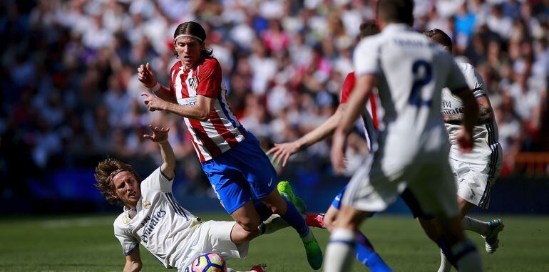 Luka Modric trata de llevarse la pelota ante Filipe Luis