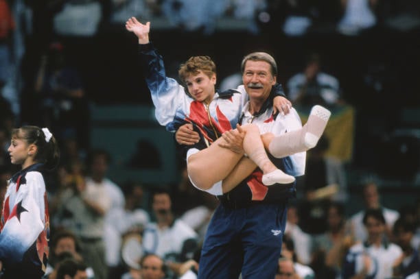 Bela Karolyi, entrenador de gimnasia rítimica, levantando a Kerri Strug tras ganar los Juegos Olímpicos de 1996