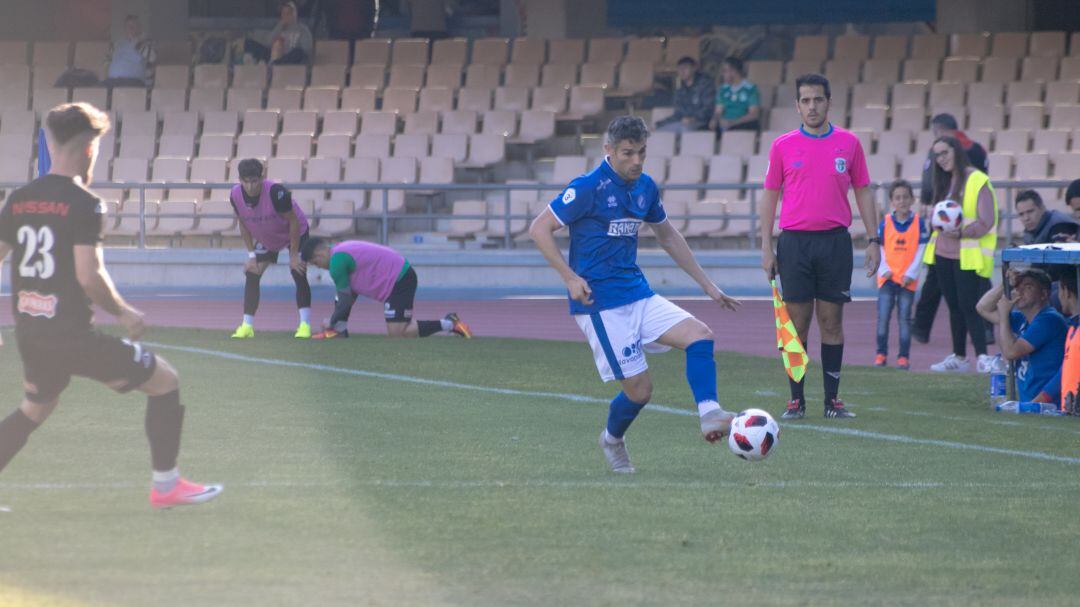Juan Gómez controlando un balón ante un jugador del Ciuda de Lucena