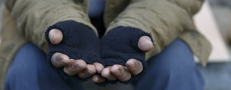 Un indigente pide en la calle