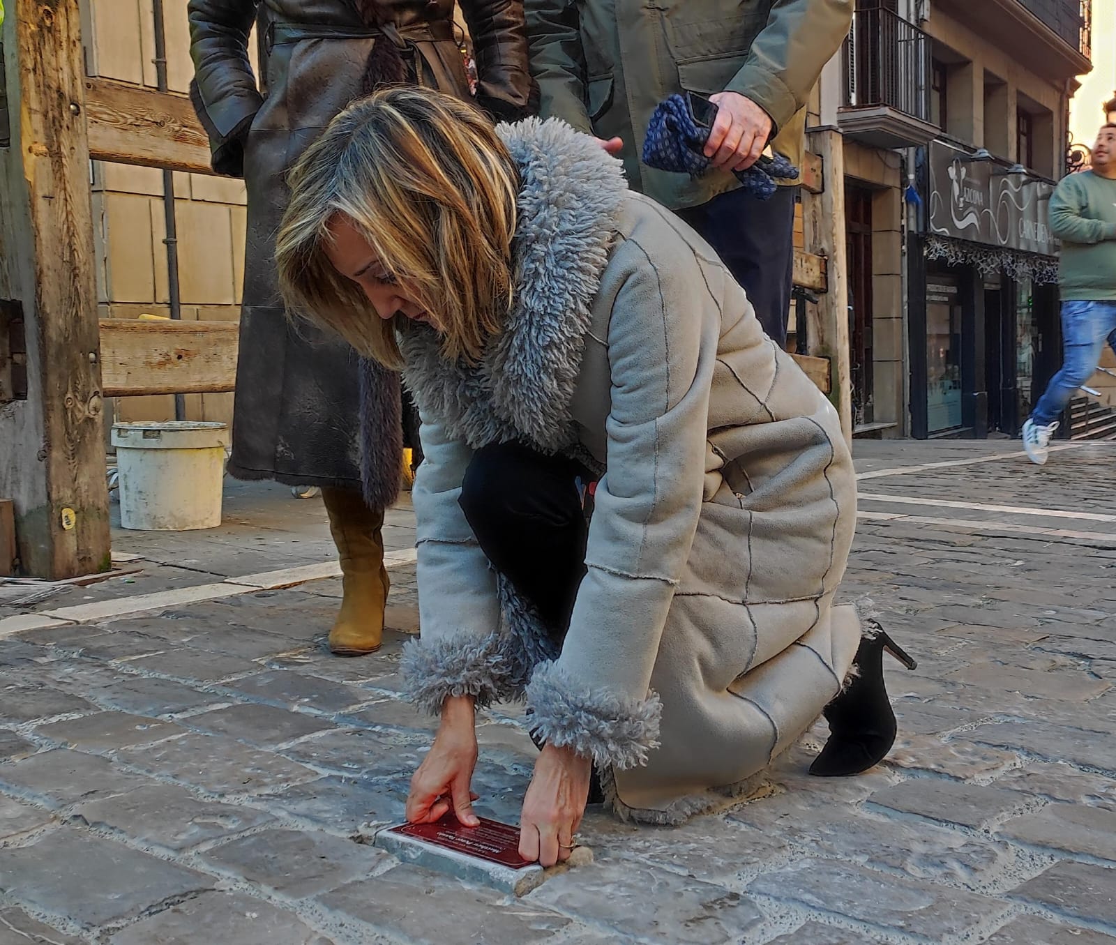 En la víspera de la moción de censura, Cristina Ibarrola (UPN), en su último día como alcaldesa de Pamplona, coloca un adoquín con una placa en recuerdo de un corredor fallecido en el encierro de los Sanfermines.