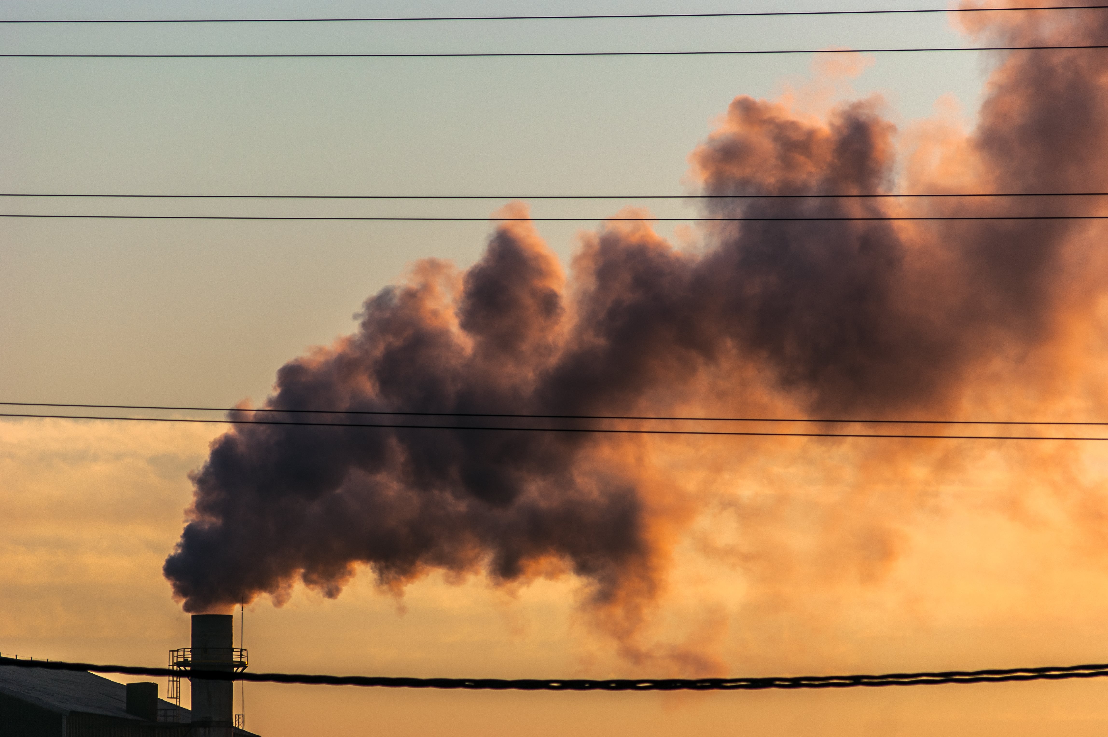 Sunset with the smoke of a chimney in the industrial area of Huelva, province of Spain