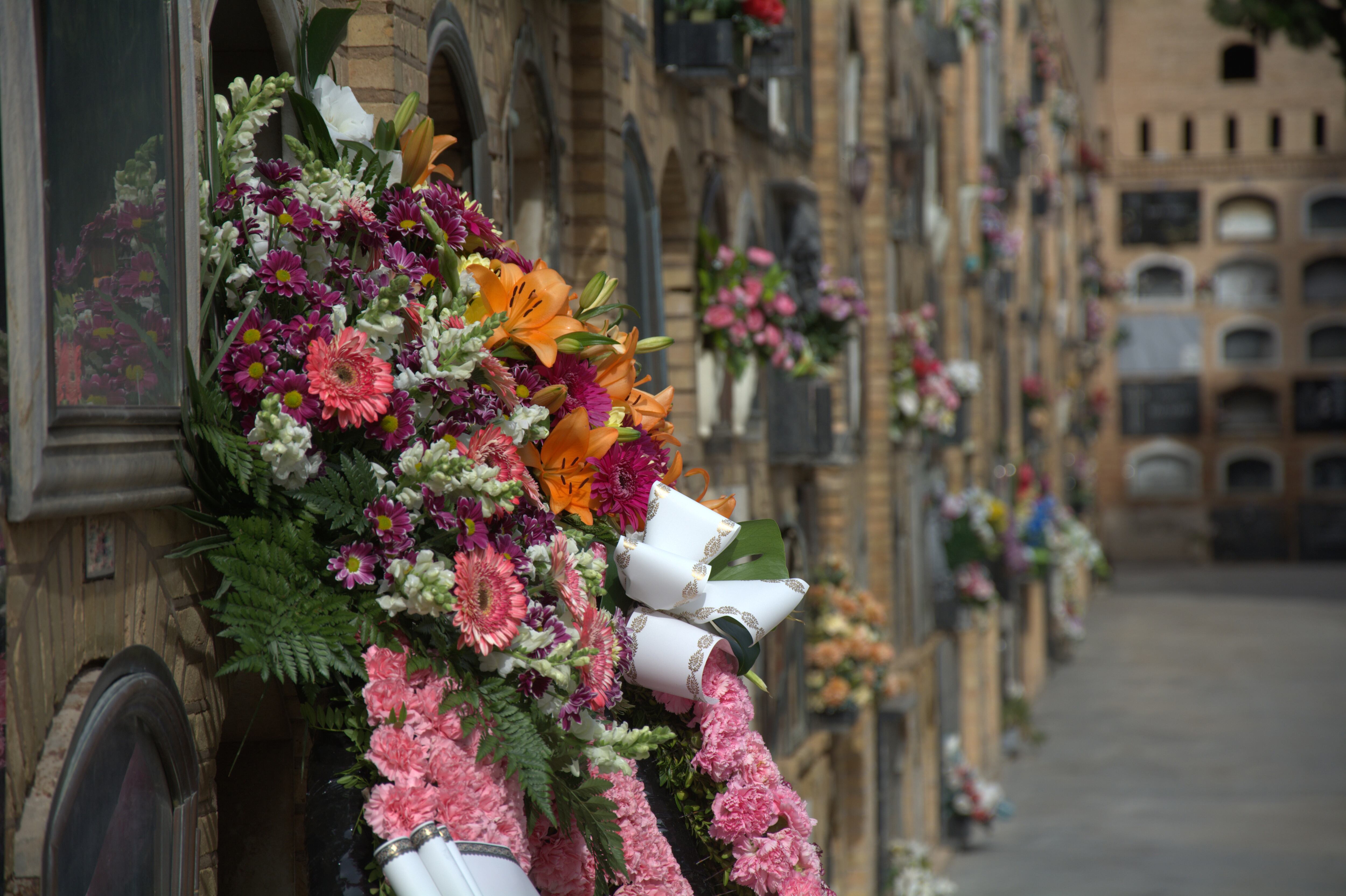 Una corona de flores adorna uno de los nichos ubicados en un cementerio