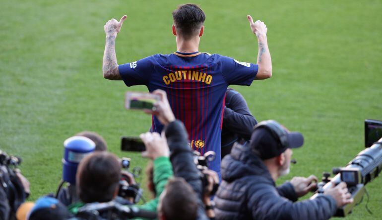 Coutinho se señala su camiseta en la presentación