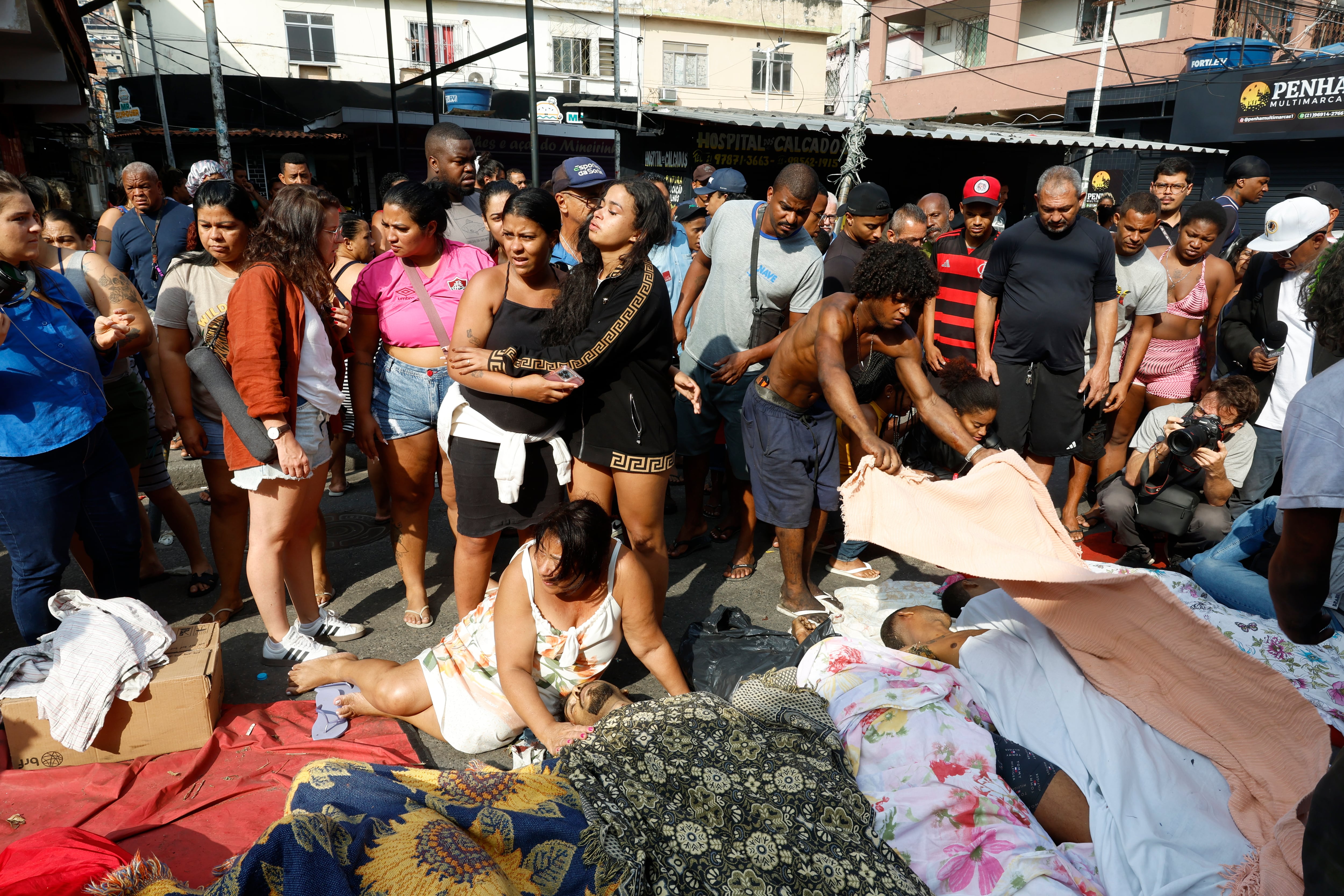 Personas observan cuerpos sin vida en una calle después del operativo policial en Río de Janeiro (Brasil).