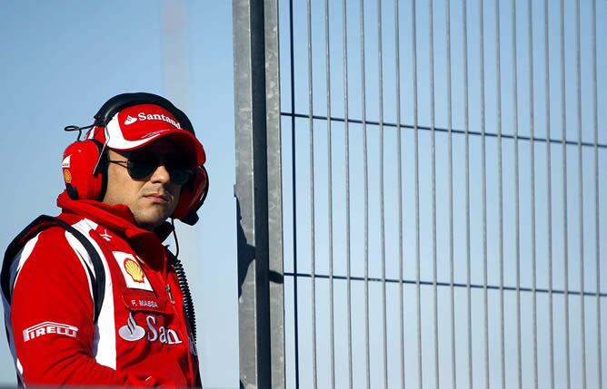 El piloto brasileño de Ferrari Felipe Massa observa a sus compañeros en pista en la primera jornada de entrenamientos de pretemporada del Mundial de Fórmula Uno en el circuito Ricardo Tormo de Cheste