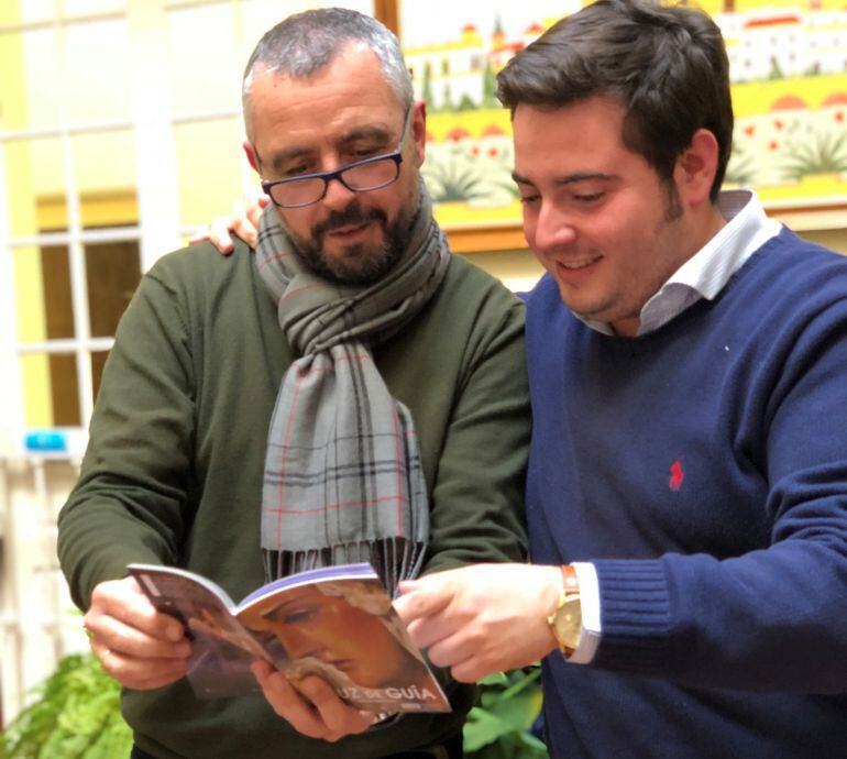 Paco García, a la izquierda, y José Manuel Peña consultan el Programa de Mano de Cruz de Guía en el patio de Radio Sevilla antes de empezar a ver cofradías
