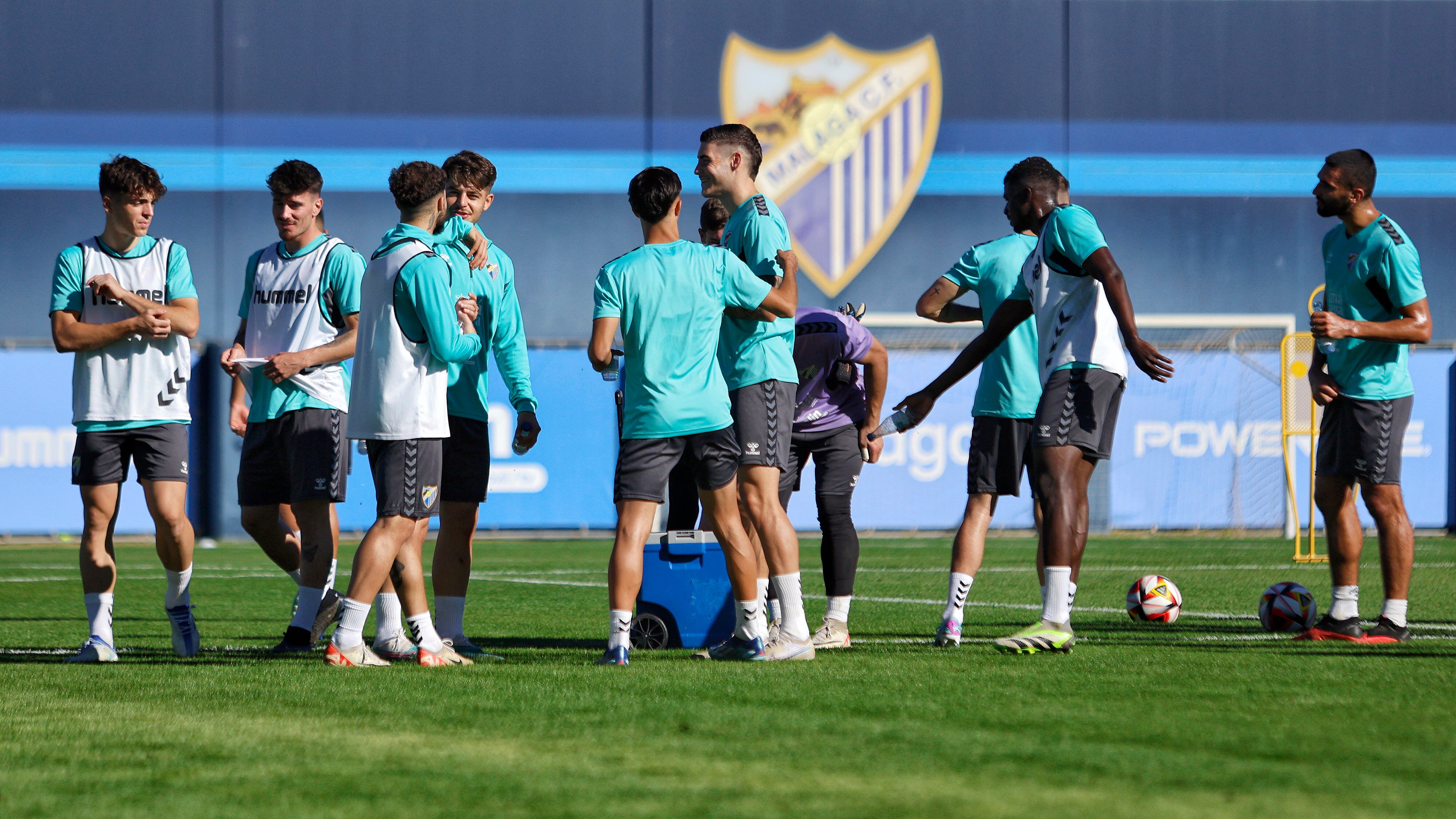 Un grupo de jugadores del Málaga se refrescan durante el entrenamiento del miércoles
