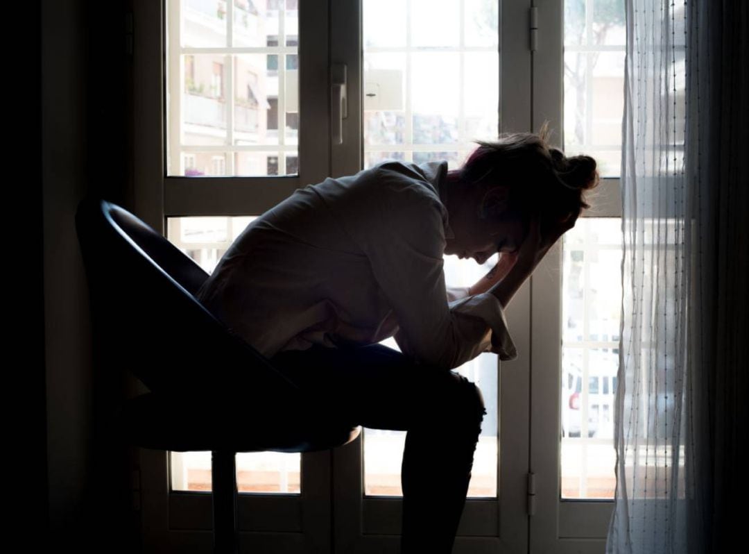 Imagen de archivo de una mujer lamentándose frente a una ventana