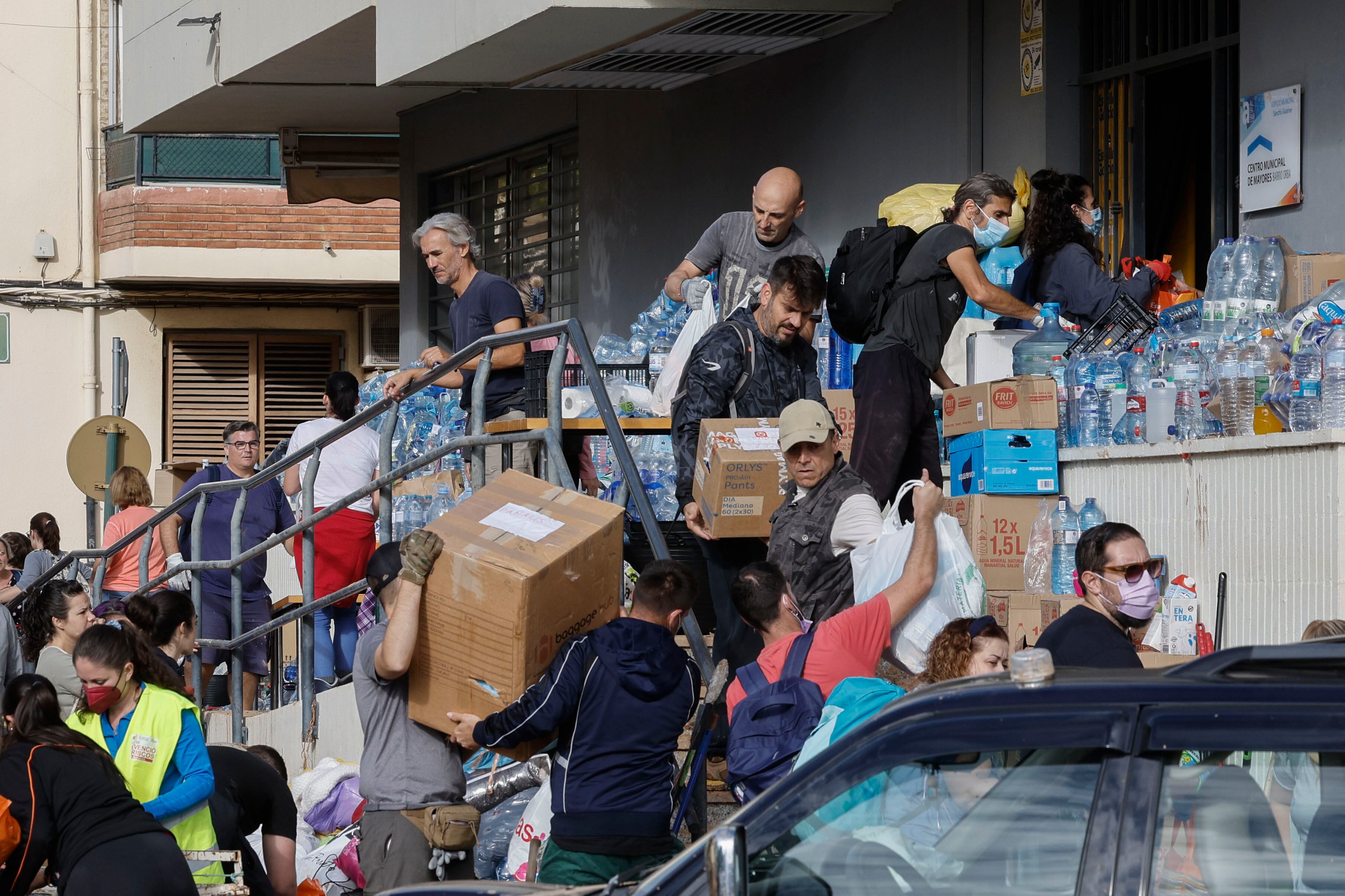 ALFAFAR, 02/11/2024.- Reparto de agua en un punto de distribución en la localidad de Alfafar, en Valencia, este sábado. Miles de personas se encuentran en la Ciudad de las Artes y las Ciencias de València esperando para subir a un autobús que les lleve a las zonas más afectadas por la Dana y ayuda en las labores de limpieza. Ataviados con palas, cepillos, baldes y litros de agua, llevan ya cerca de una hora conformando la fila para partir a pueblos como Sedaví, Alfafar o Catarroja. EFE/ Kai Försterling
