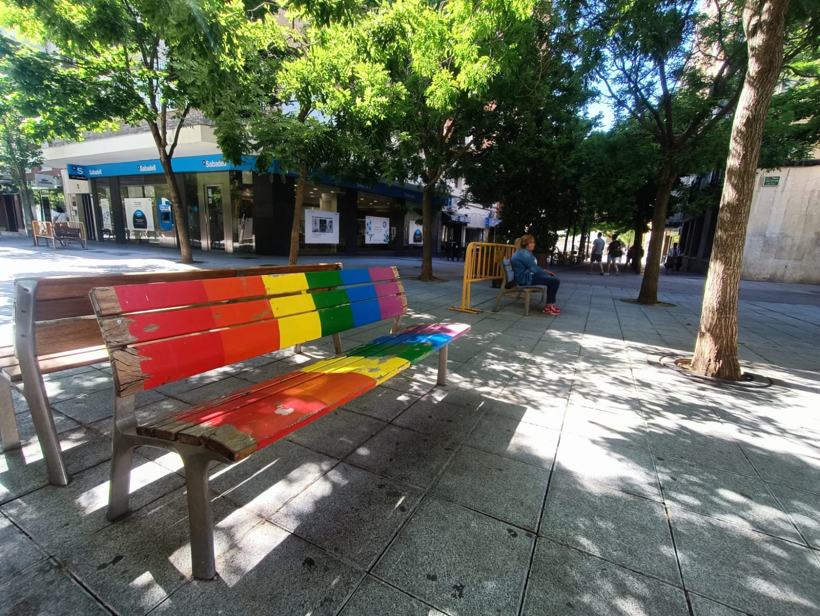 Uno de los bancos con la bandera arcoiris en la plaza Concepción Arenal