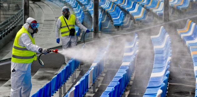 Técnicos de limpieza desinfectando el estadio