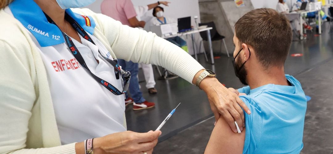 Un hombre recibe la vacuna contra la covid en el punto de vacunación masivo instalado en el Wizink Center de Madrid