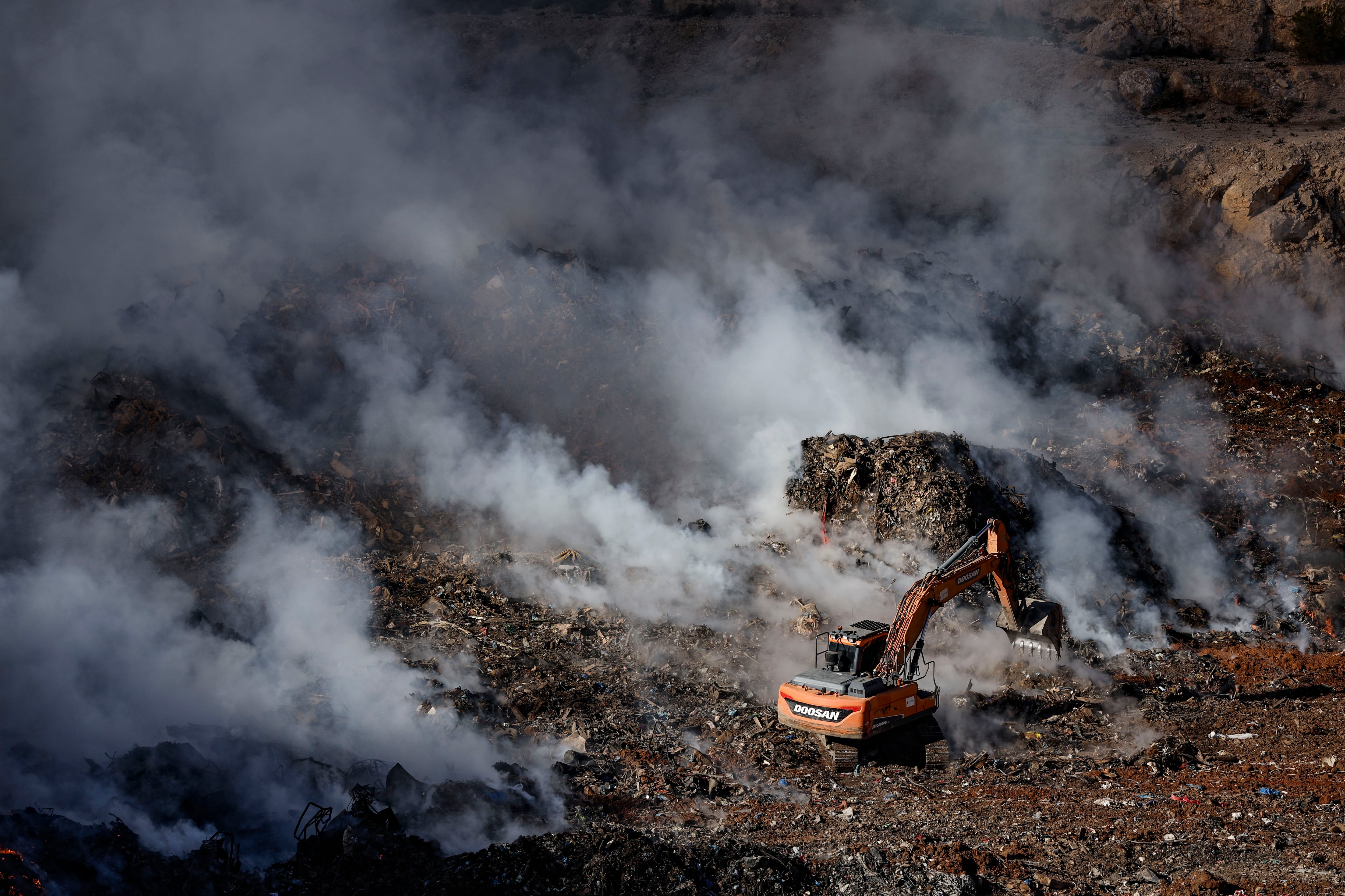 El incendio el lunes, un día después de que se declarara, en el vertedero habilitado en una antigua cantera donde se depositan enseres arrasados por la dana. EFE/Biel Aliño