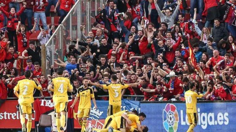 Los jugadores de Osasuna celebran el gol de Kodro que valía un ascenso ante el delirio de la afición rojilla desplazada hasta Girona