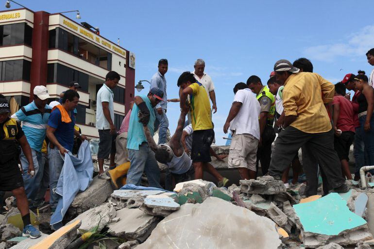 Pobladores rescatan un cuerpo entre los escombros en la localidad de Pedernales (Ecuador), hoy domingo 17 de abril de 2016, después del terremoto de 7,8 grados en la escala de Richter registrado el sábado en la costa norte de Ecuador. El presidente de Ecu