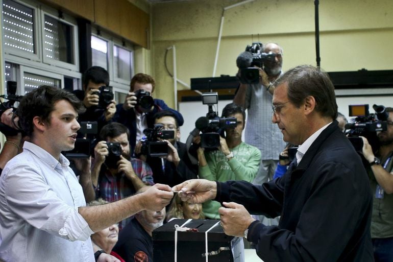 El primer ministro luso y líder de la coalición conservadora Portugal à Frente, Pedro Passos Coelho (d), vota en un colegio electoral en Massama (Portugal).