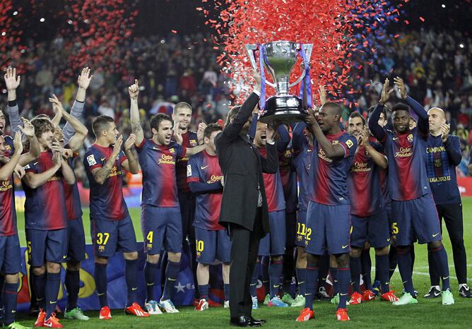 El entrenador del F.C.Barcelona, Tito Vilanova (c.i), y el francés Eric Abidal (c. d), junto al resto de la plantilla, con el trofeo que acredita al FC Barcelona como campeón de la Liga 2012-2013