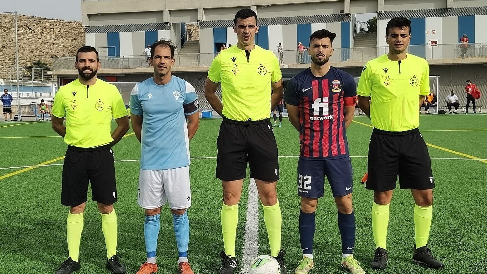 El capitán del Eldense, Adri Gran, y el del Alicante, Edu Serrano, flanqueando al colegiado del encuentro, Jorge Leal