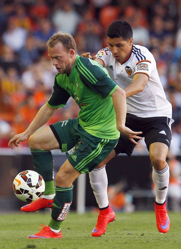 GRA390. VALENCIA, 17/05/2015.- El centrocampista argentino del Valencia Enzo Nicolás Pérez (d) disputa un balón con el centrocampista danés del Celta de Michael Krohn-Dehli (i), durante el partido de la trigésima séptima jornada de la Liga de Primera División que se juega hoy en el estadio Mestalla. EFE/Kai Försterling