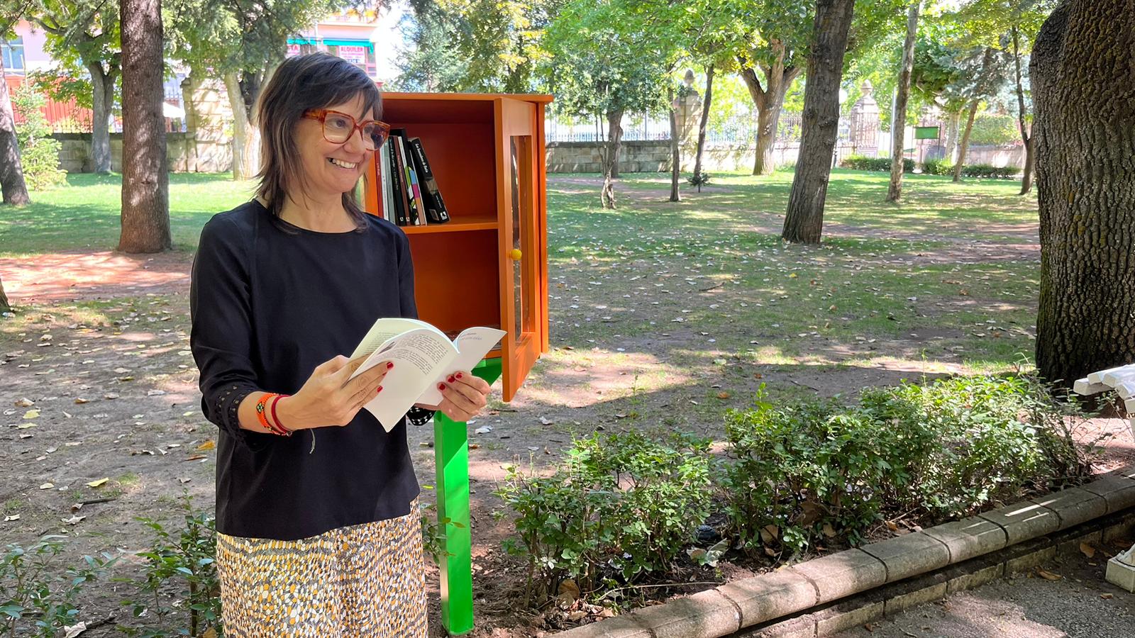 La concejala del Ayuntamiento de Soria, Gloria Gonzalo, junto a una de las cajas de libros en La Dehesa.