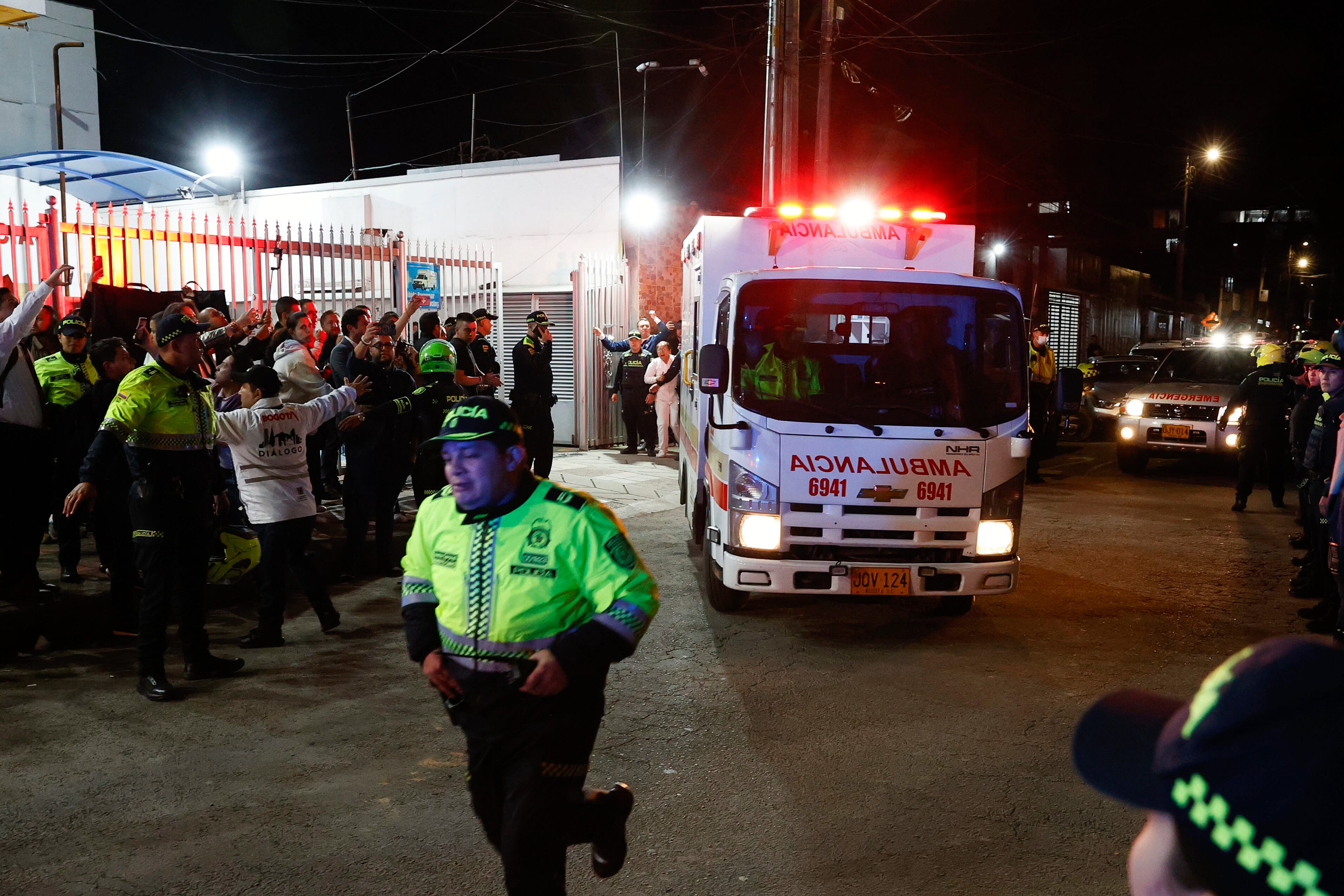 Policías custodian la ambulancia en la que es trasladado el senador Miguel Uribe Turbay, este sábado, en Bogotá