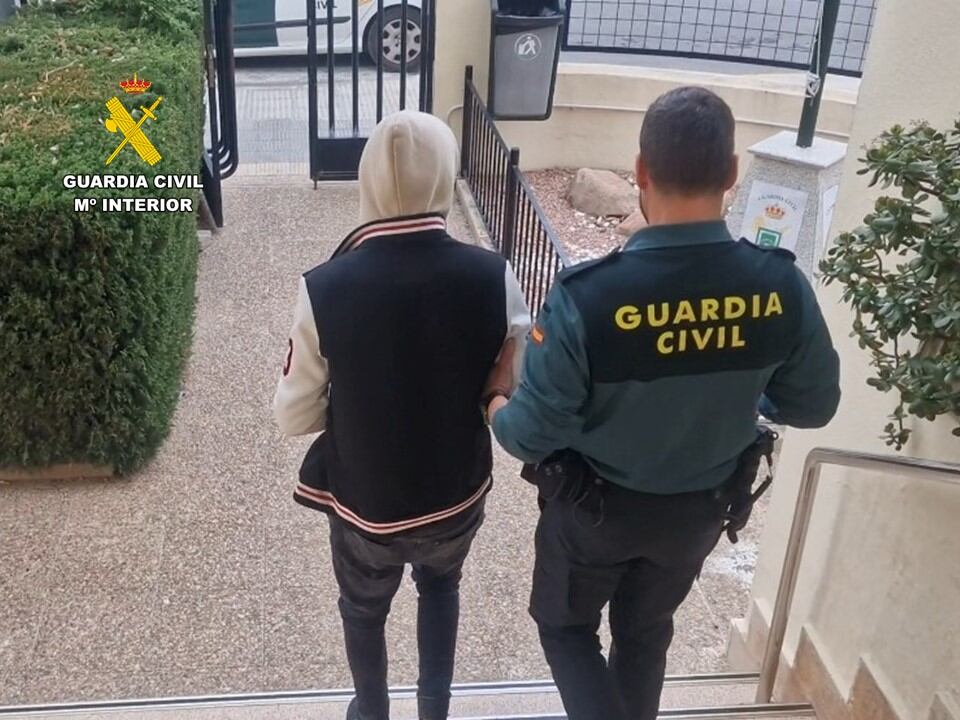 Un agente de la Guardia Civil custodia al detenido por el robo con violencia