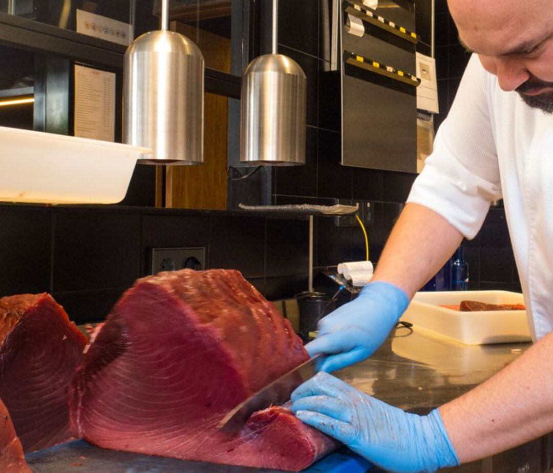 Imagen de archivo de un cocinero con una pieza de atún rojo