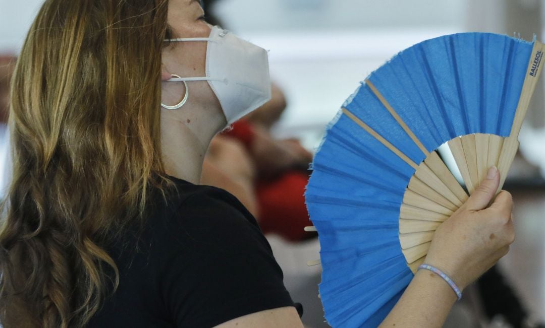 Una mujer con mascarilla se abanica en Madrid. 