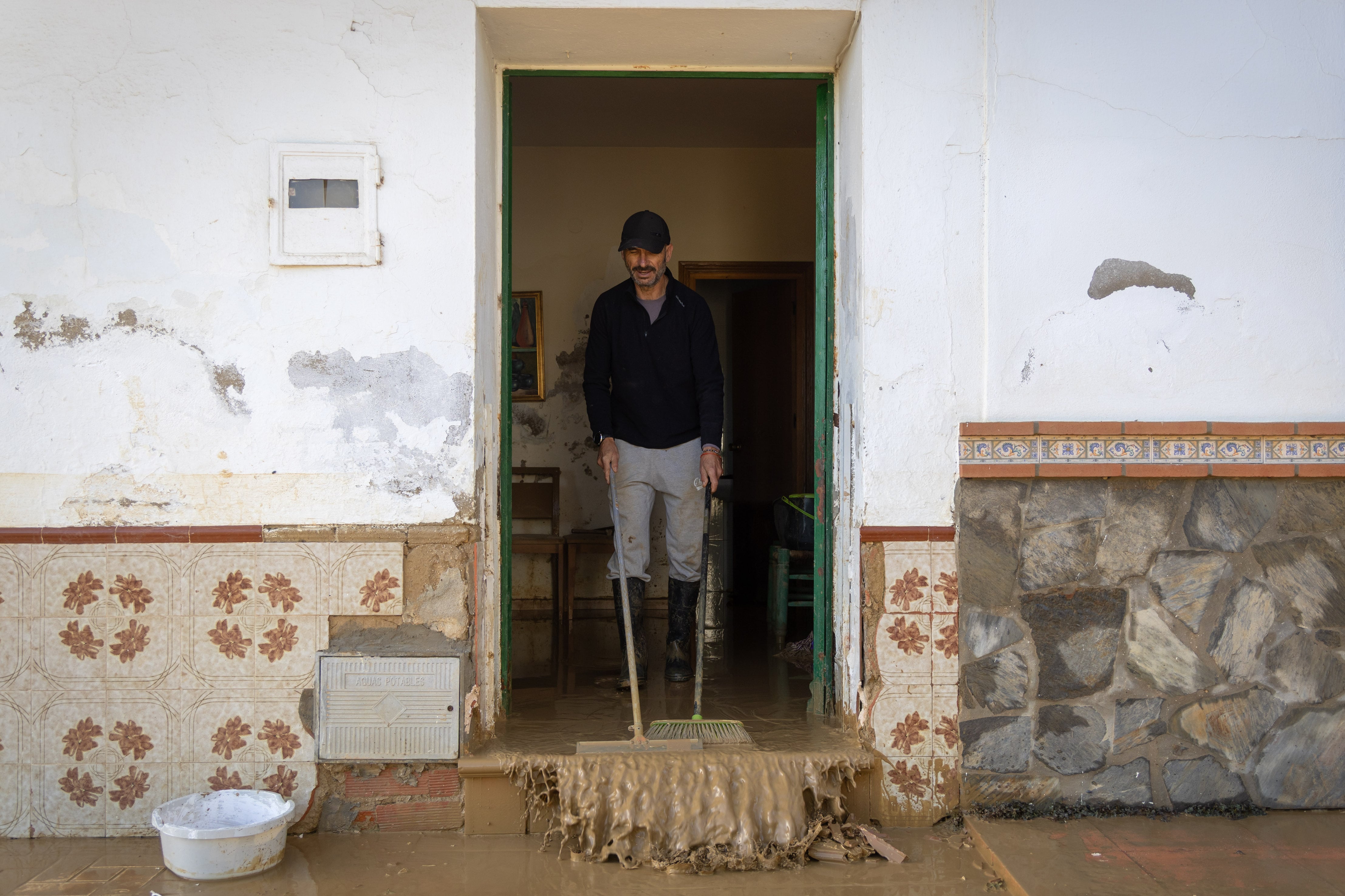 CÁRTAMA (MÁLAGA), 05/01/2026.- Un vecino de la barriada de Doña Ana, próxima al municipio de Cártama, limpia de lodo y barro el interior de su vivienda ante la crecida del río Guadalhorce y las precipitaciones intensas del día de ayer tras decretarse la alerta roja. EFE/Álvaro Cabrera