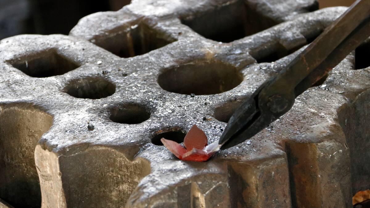Agafen el ferro amb les estenalles, l'escalfen en el fornal avivat per la manxa..